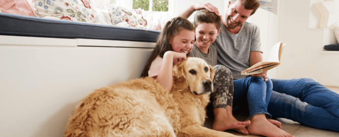 Happy family of three with their Golden Retriever on the floor of home with solar