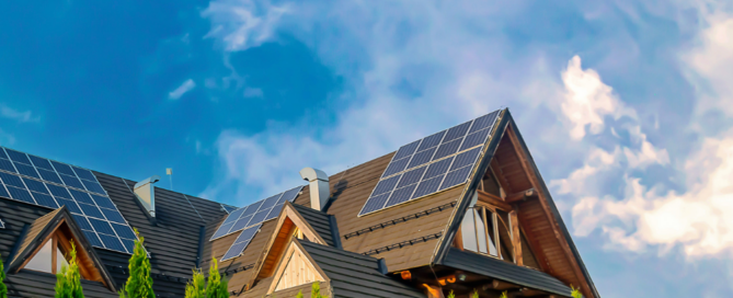 Modern home with rooftop solar panels under a bright summer sky, showcasing smart reasons to go solar this summer for energy savings and sustainability.