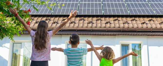 Sea Bright Solar residential home with rooftop solar panels as children stand with arms raised, representing solar incentives and clean energy savings