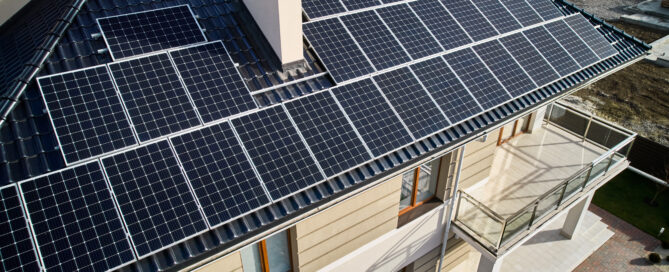 Aerial view of a residential roof covered with solar panels.
